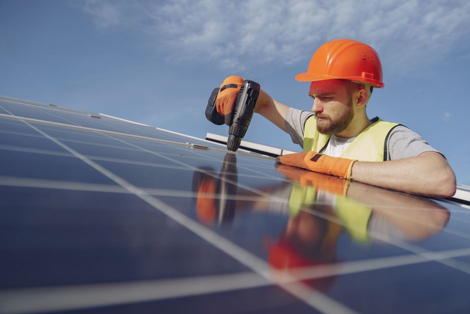 Solar panel installer working on a residential rooftop